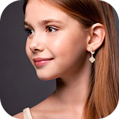 Modelo jovem com cabelo castanho claro usando brincos delicados de gota prateada.