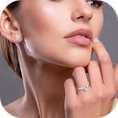 Close do rosto feminino destacando brinco pequeno de diamante e anel de noivado prateado.