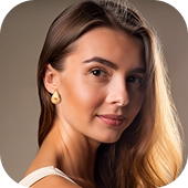 Modelo feminina com brinco redondo dourado e colar delicado, sorrindo levemente.