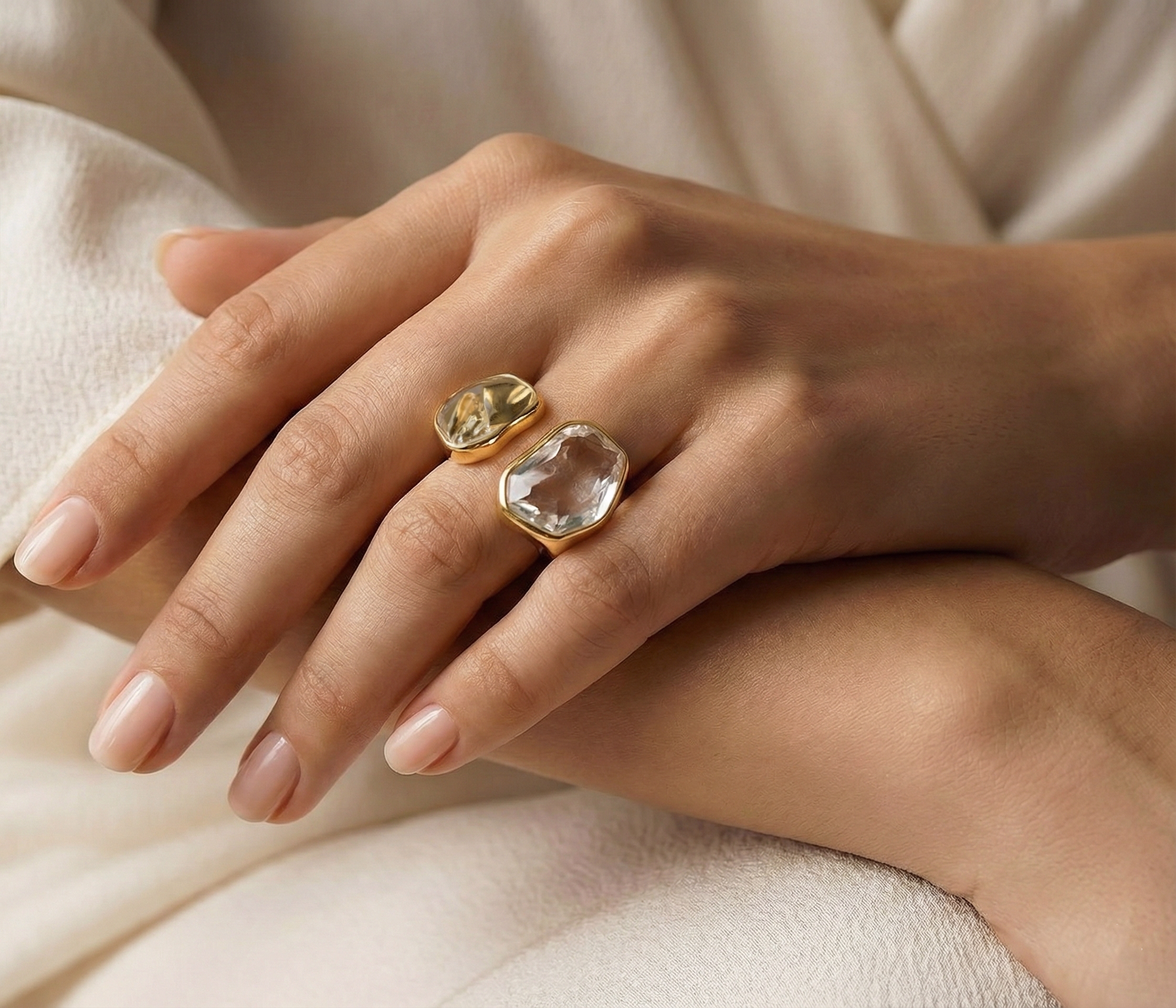 Modelo feminina com brinco redondo dourado e colar delicado, sorrindo levemente.