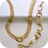 Corrente dourada com elos grandes e pequenos intercalados, em fundo branco.