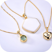 Conjunto de colares dourados com pingentes geométricos e coração, dispostos lado a lado.