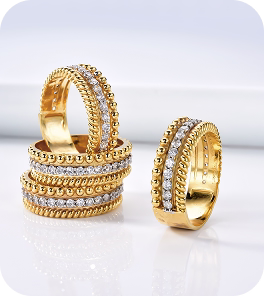 Conjunto de anéis dourados com detalhes em zircônias, empilhados em composição elegante.